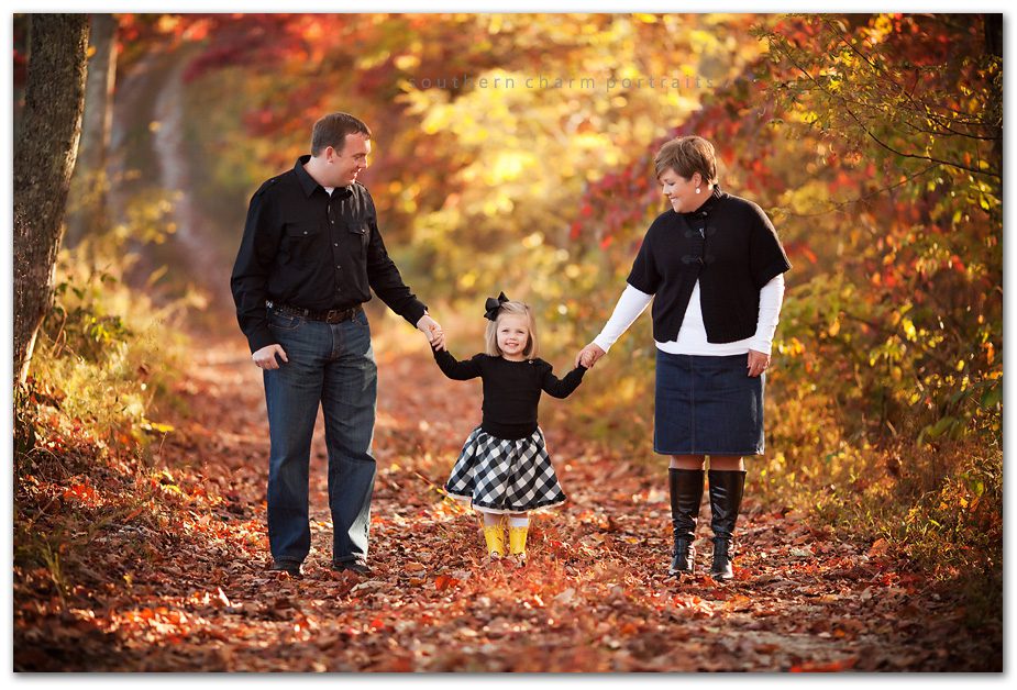 family of three dressed in black and white attire with yellow rain boots fall colors