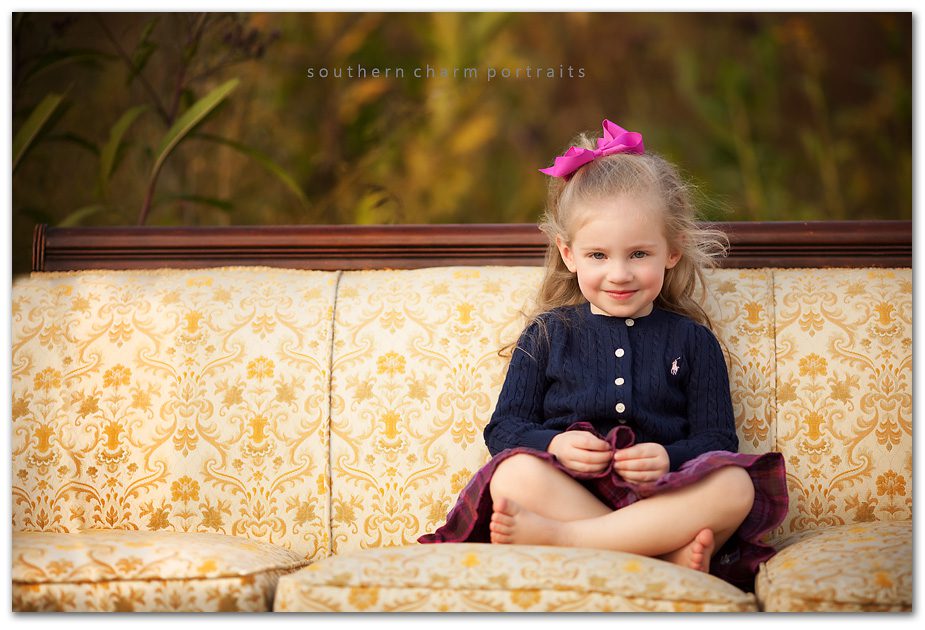 little girl on vintage couch in field with ralph lauren sweater