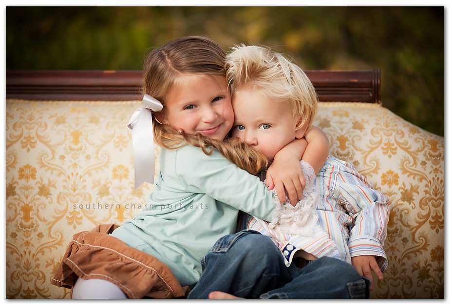brother and sister hugging- adorable! ON VINTAGE COUCH, at that!