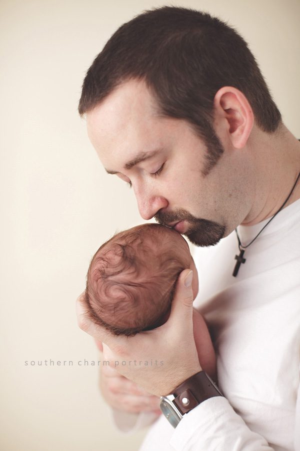 father kissing newborn baby girl