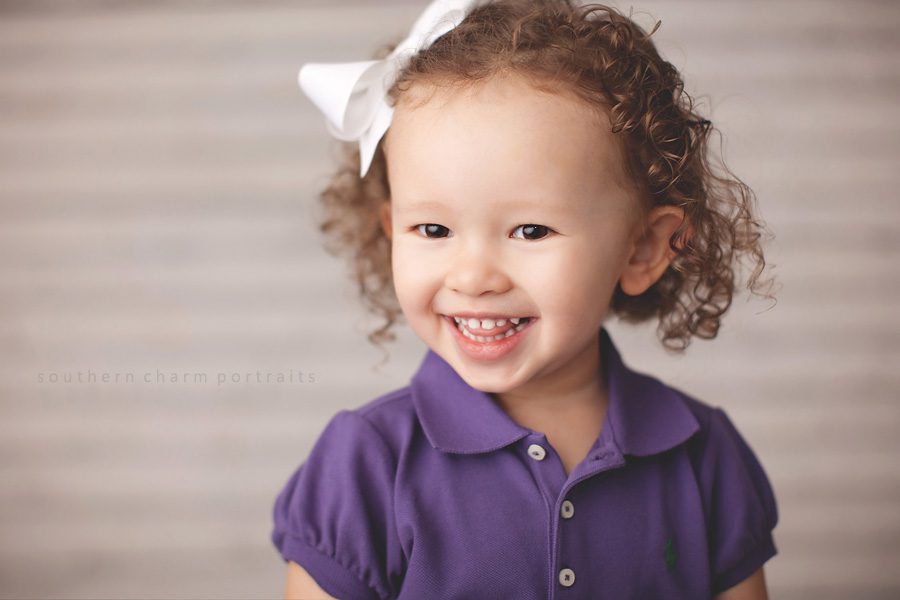 little girl wearing a purple polo shirt