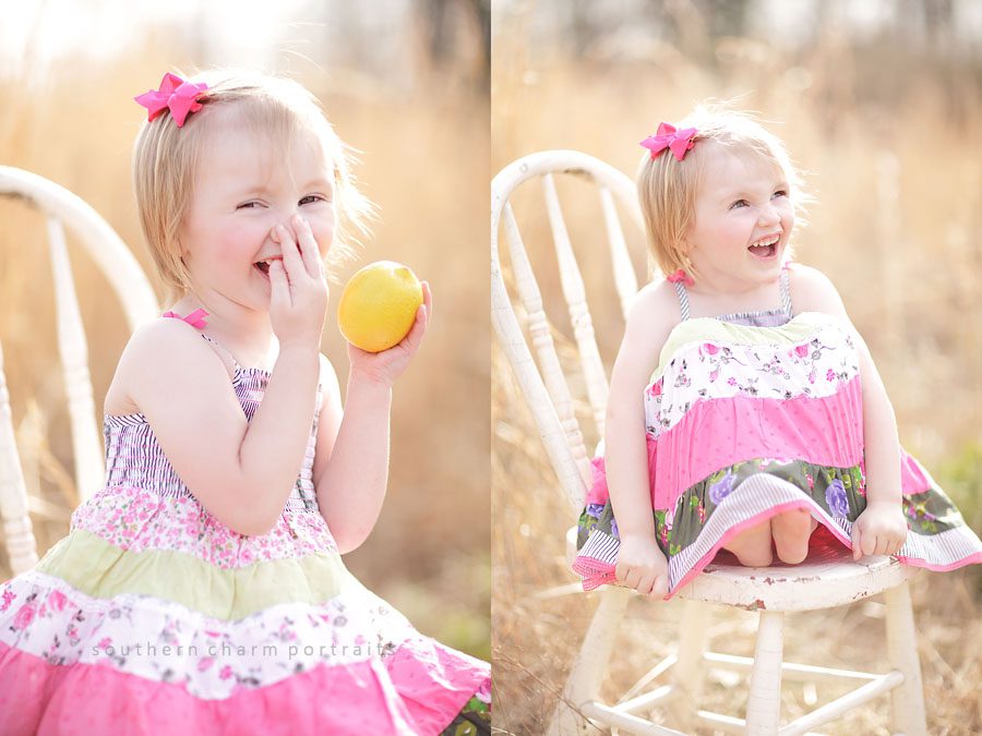little girl laughing holding a lemon sitting in antique chair