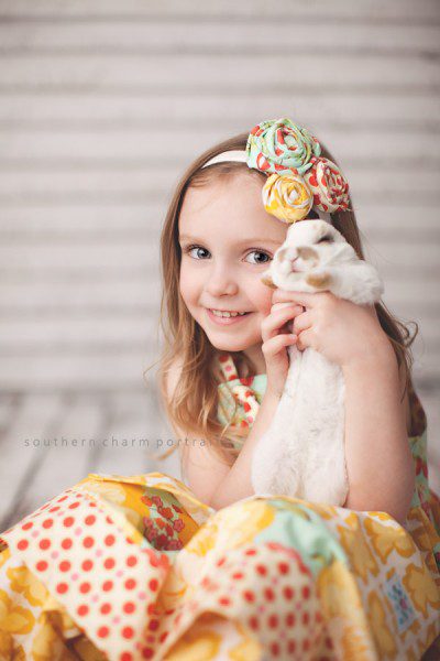 little girl holding bunny up at her face in portrait studio in lafollette, tn