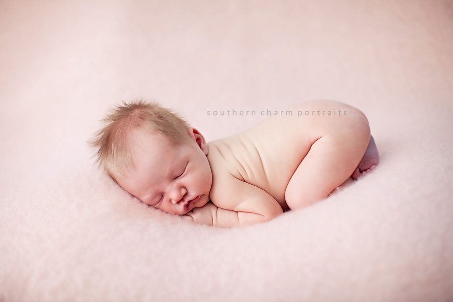 baby girl sleeping on pink blanket