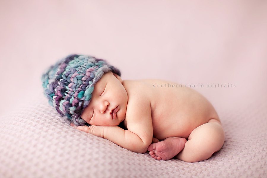 baby sleeping on blanket with knit hat