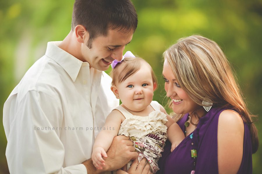 family of three outdoors for a portrait session, mother, father, and baby girl