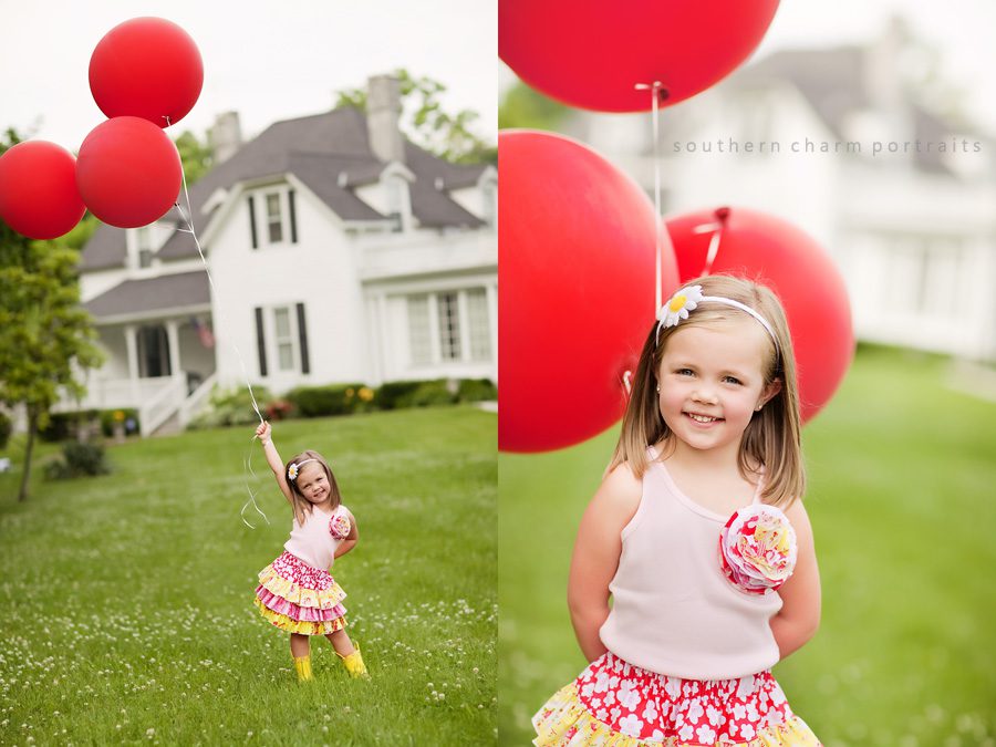 little girl holding three giant red balloons in cute outfit